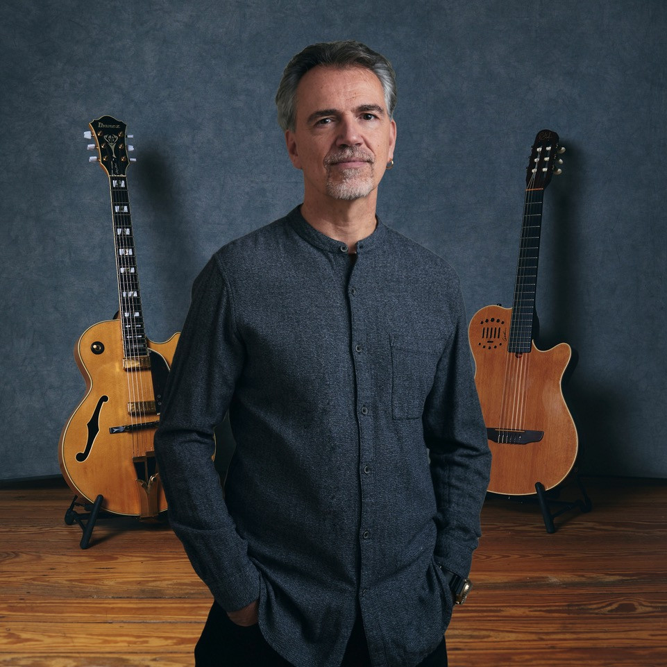 Portrait of Roland Cabezas with two guitars in the background